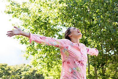 Pretty brunette feeling free in the park on a summers day