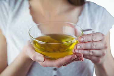 Pretty woman with herbal tea on white background