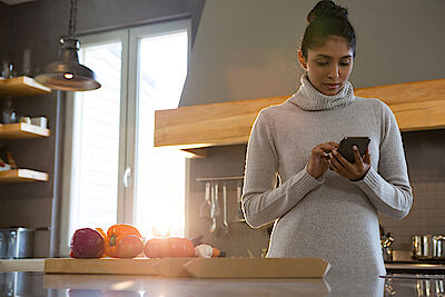 Woman using phone in kitchen